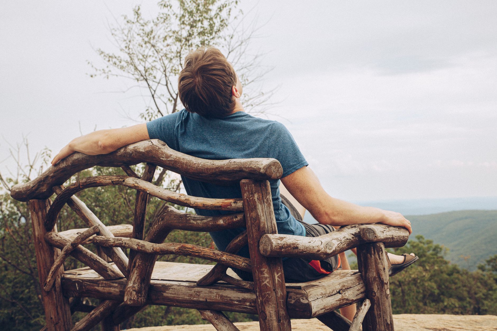 a person sitting on the wooden chair